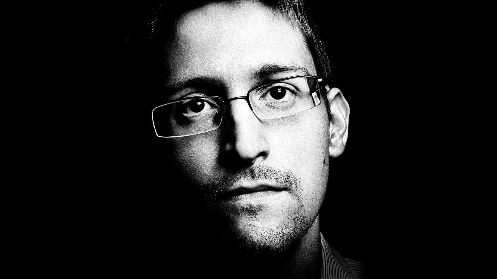 Ein Bild von Edward Snowden, einem Mann mit Brille und Bart.